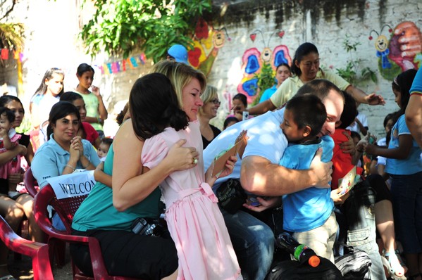 children hugging two adults