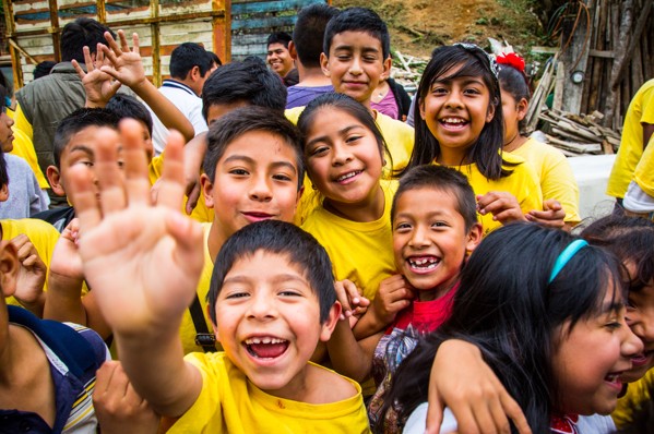 group of children waving at camera