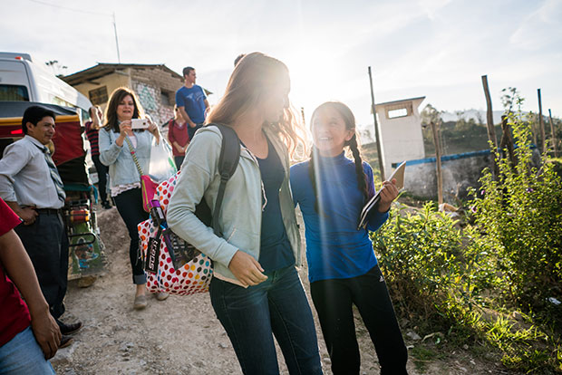 A young sponsor walks with another young girl and smiles